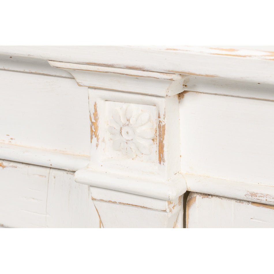 Decorative detail, white buffet, floral motif, close-up.