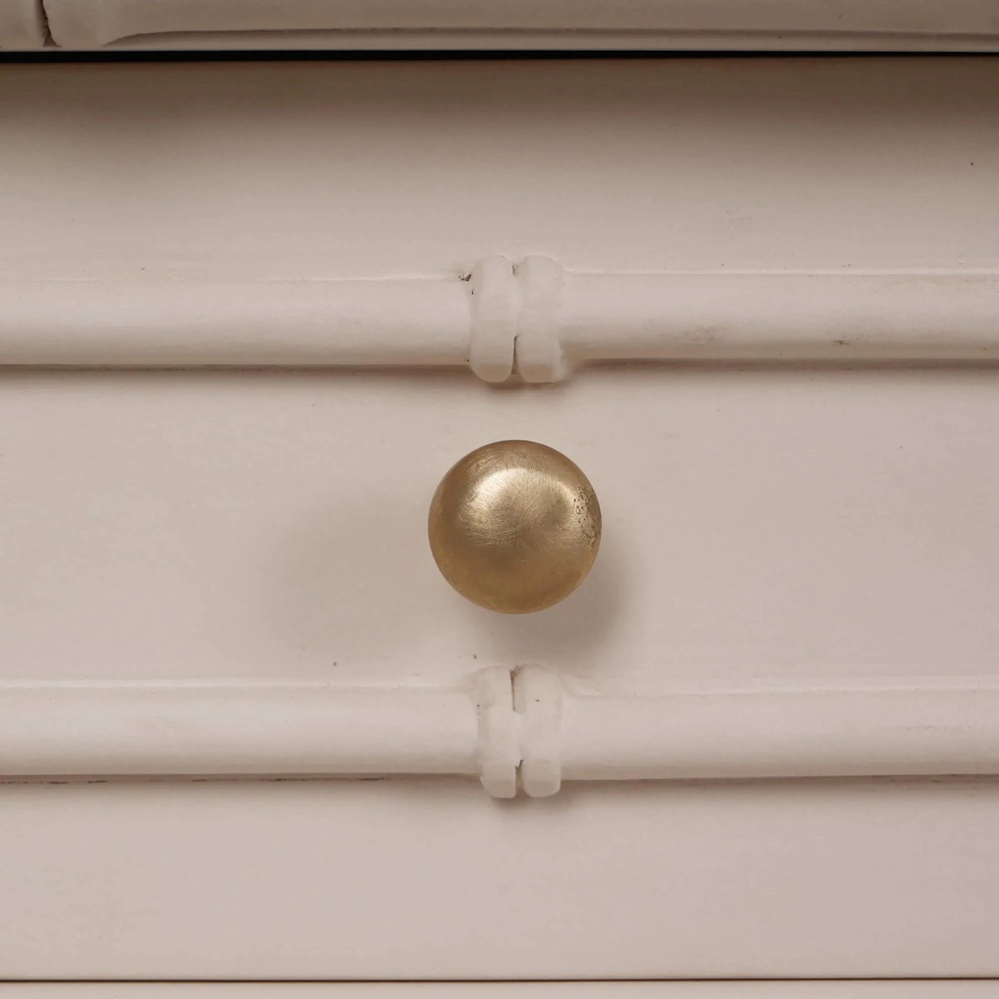 Brass knob detail on faux bamboo console table.