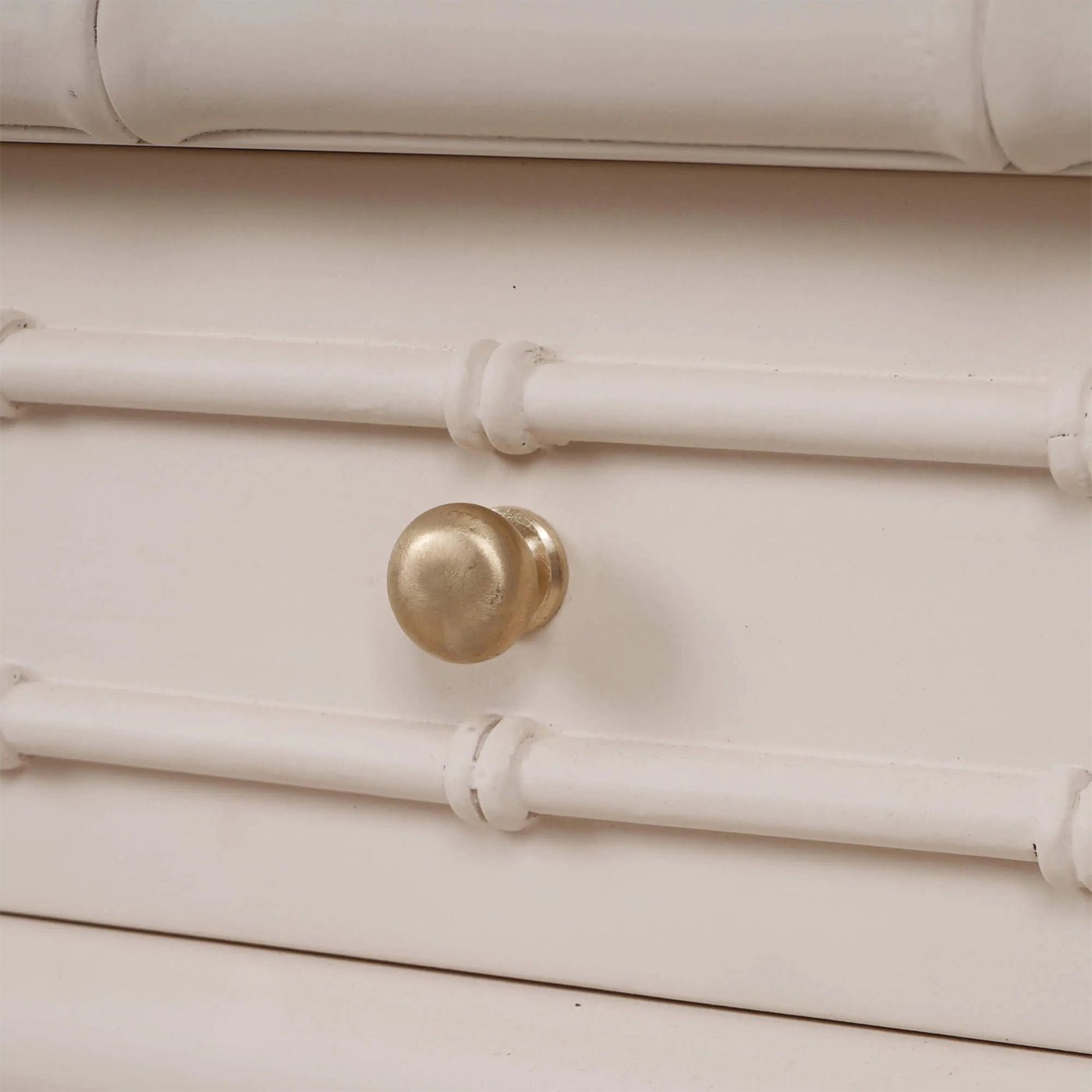 Close-up of drawer knob and design on console table.