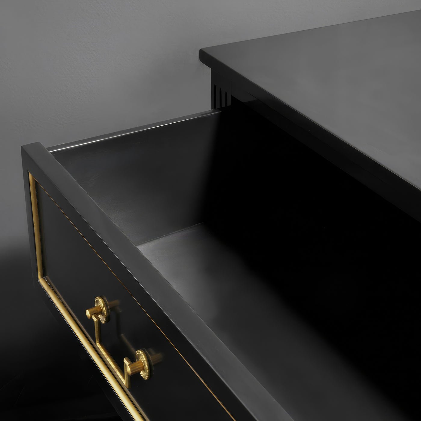 Open drawer of black Louis XVI dresser, interior view.