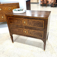 Bedside chest showcased on showroom floor with decorative plate.