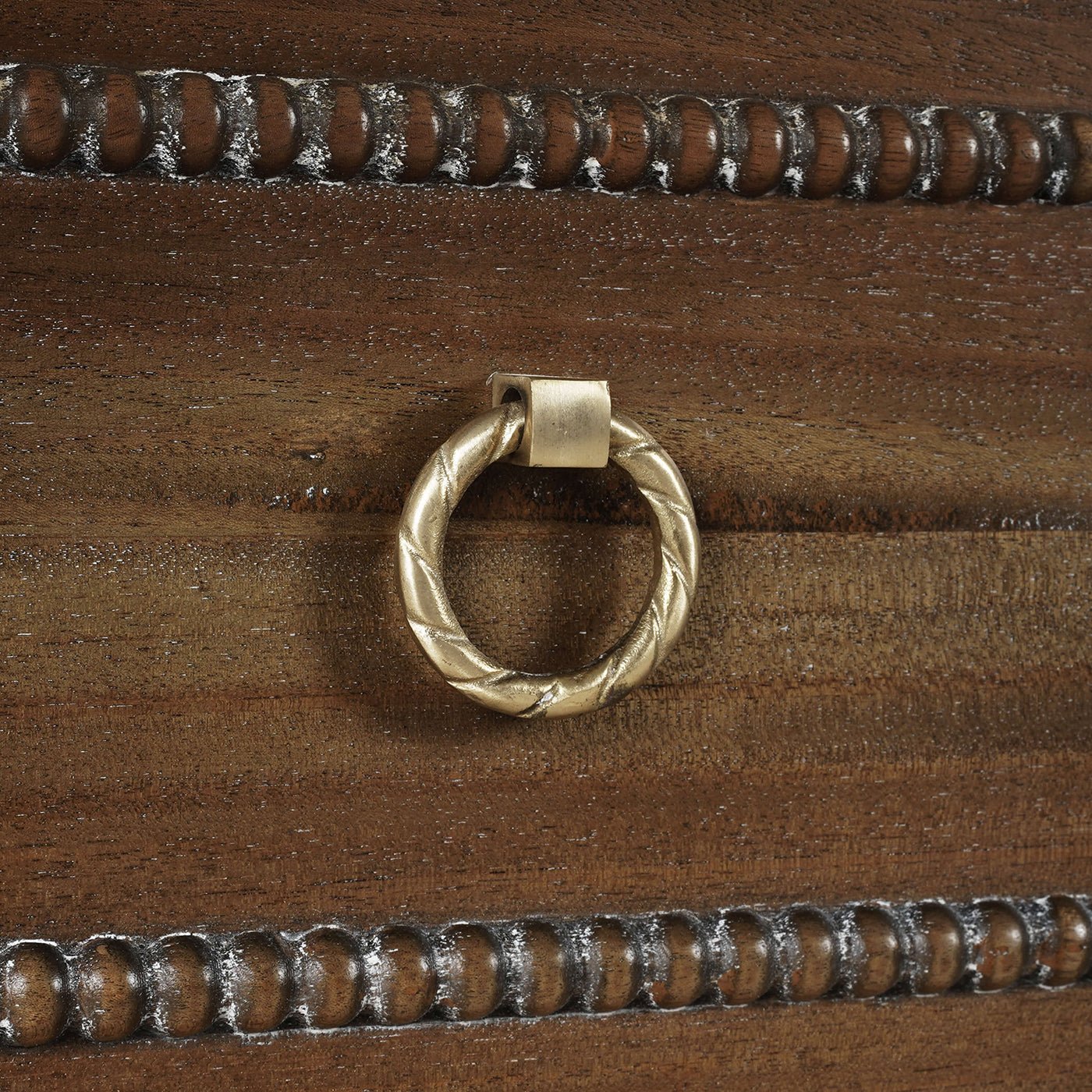 Close-up of drawer handle on mahogany chest.