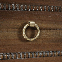 Close-up of drawer handle on mahogany chest.
