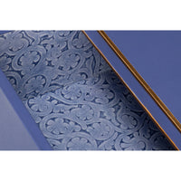 Drawer interior with ornate pattern on blue nightstand.
