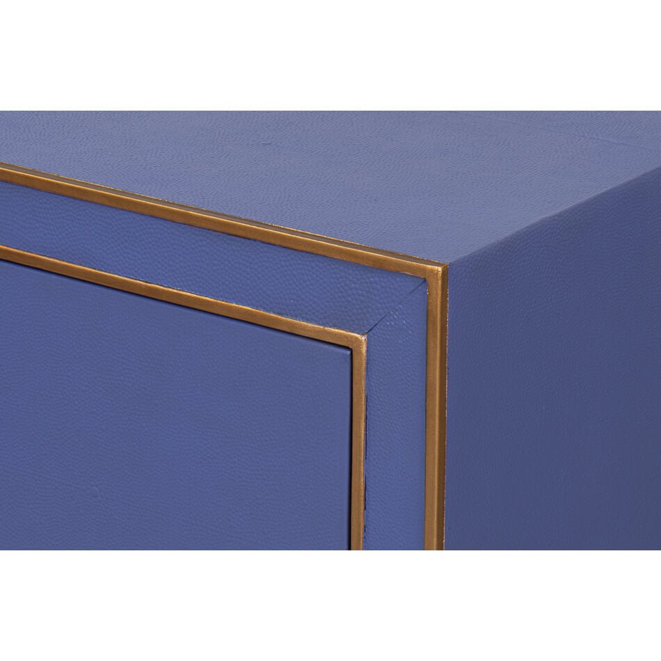 Corner detail of blue nightstand with gold trim.