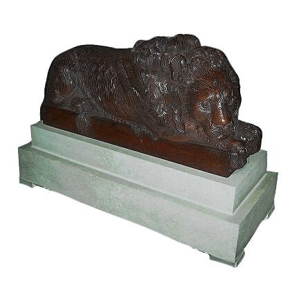 Medium carved lion sculpture on a stone pedestal.