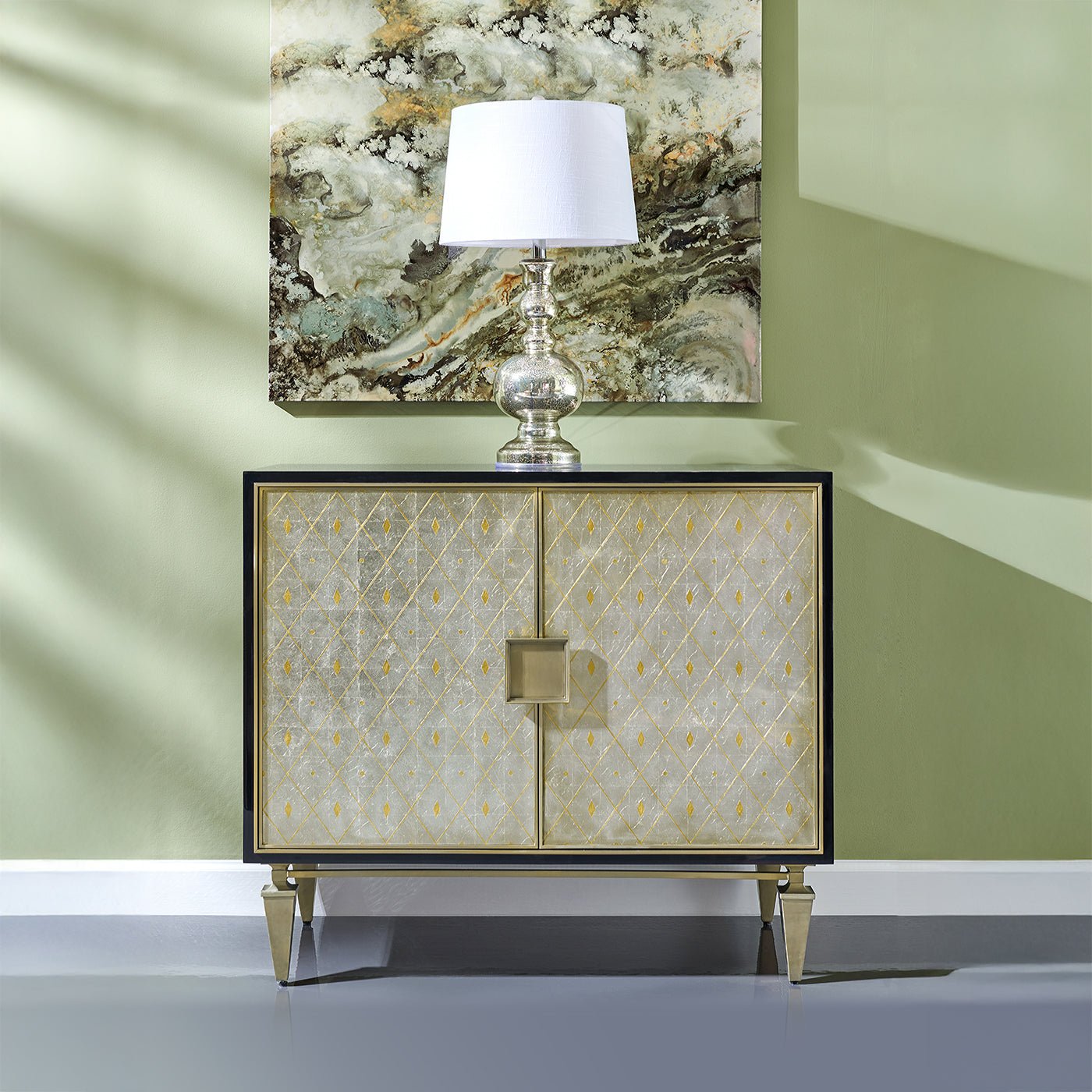 Accent cabinet in room with lamp and artwork above.