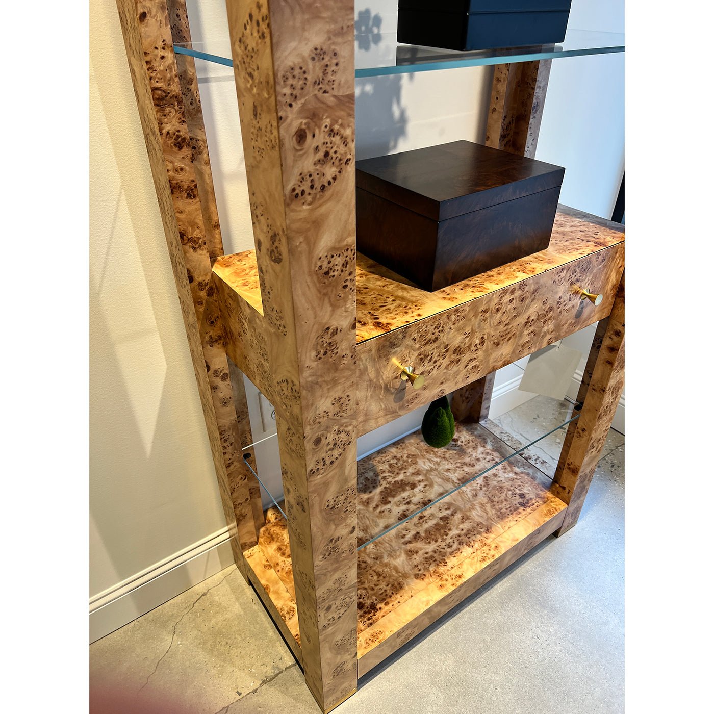 Side view of burl étagère bookshelf with drawer.