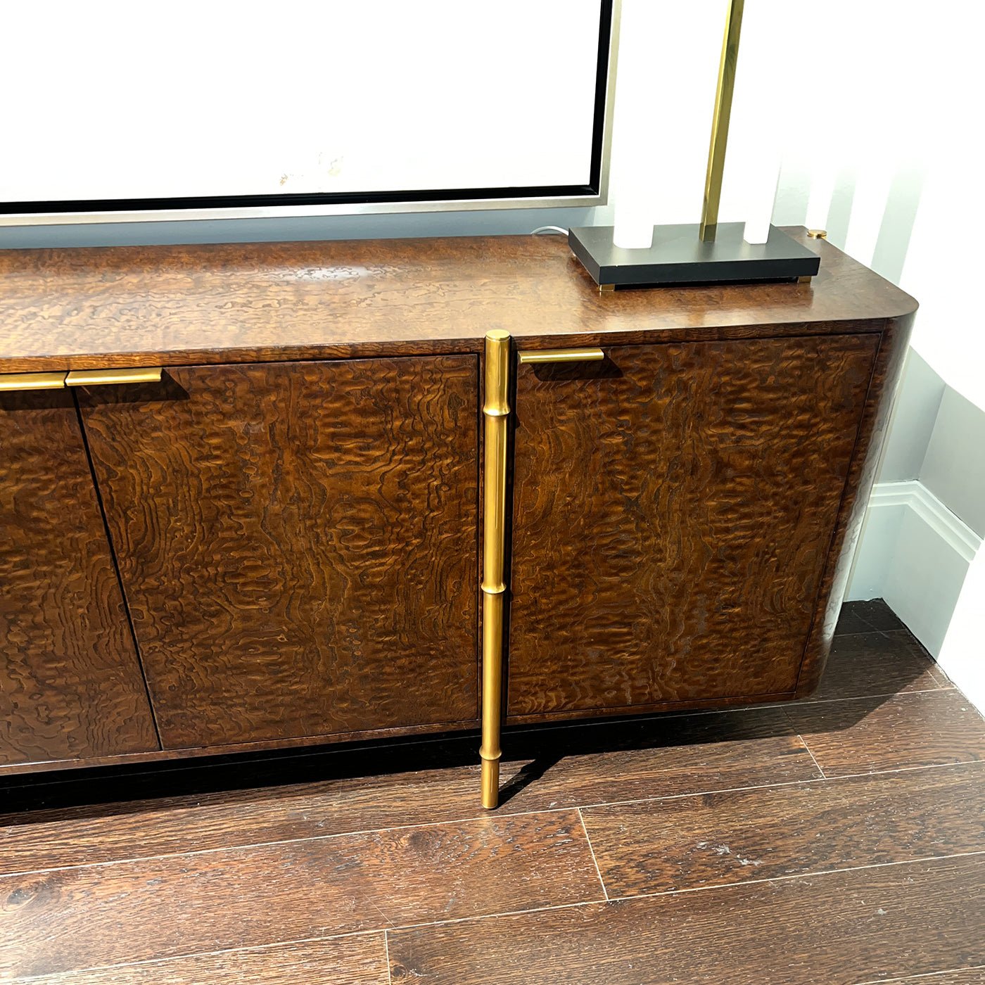 Close-up of burl wood sideboard highlighting design details.