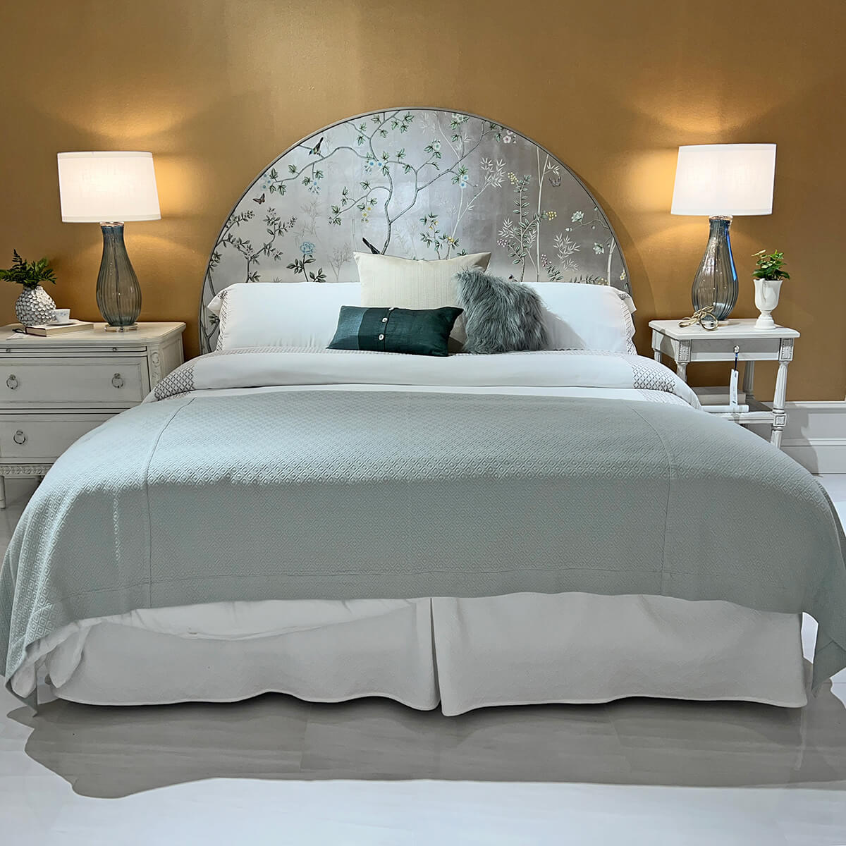 King bed in elegant bedroom setting with lamps.