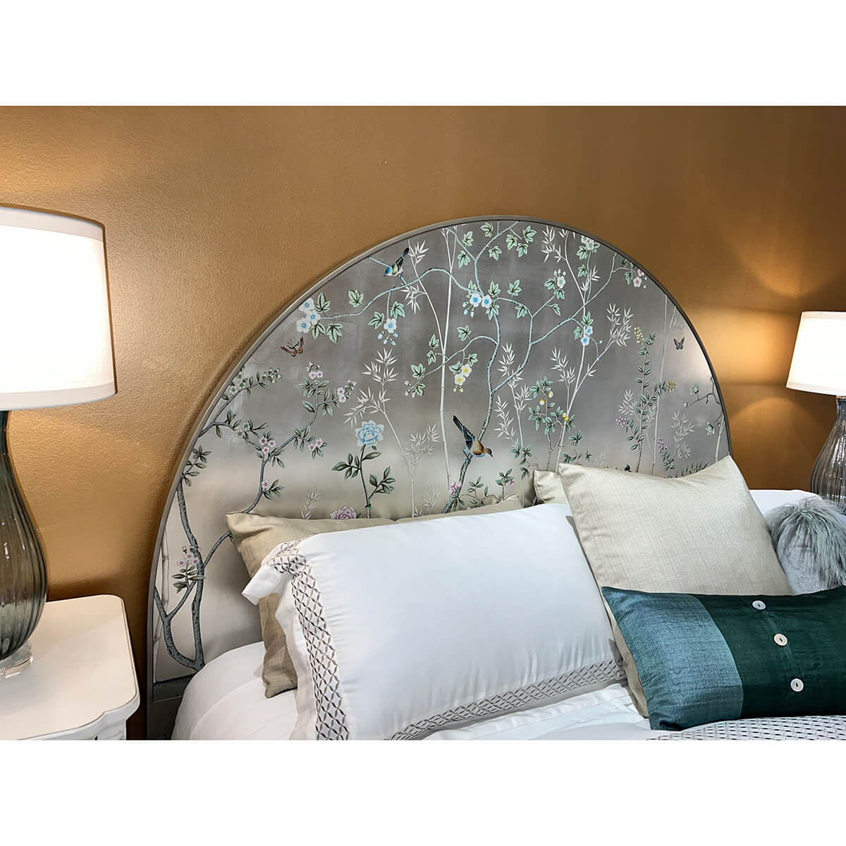 Chinoiserie headboard with bedding and decorative pillows.