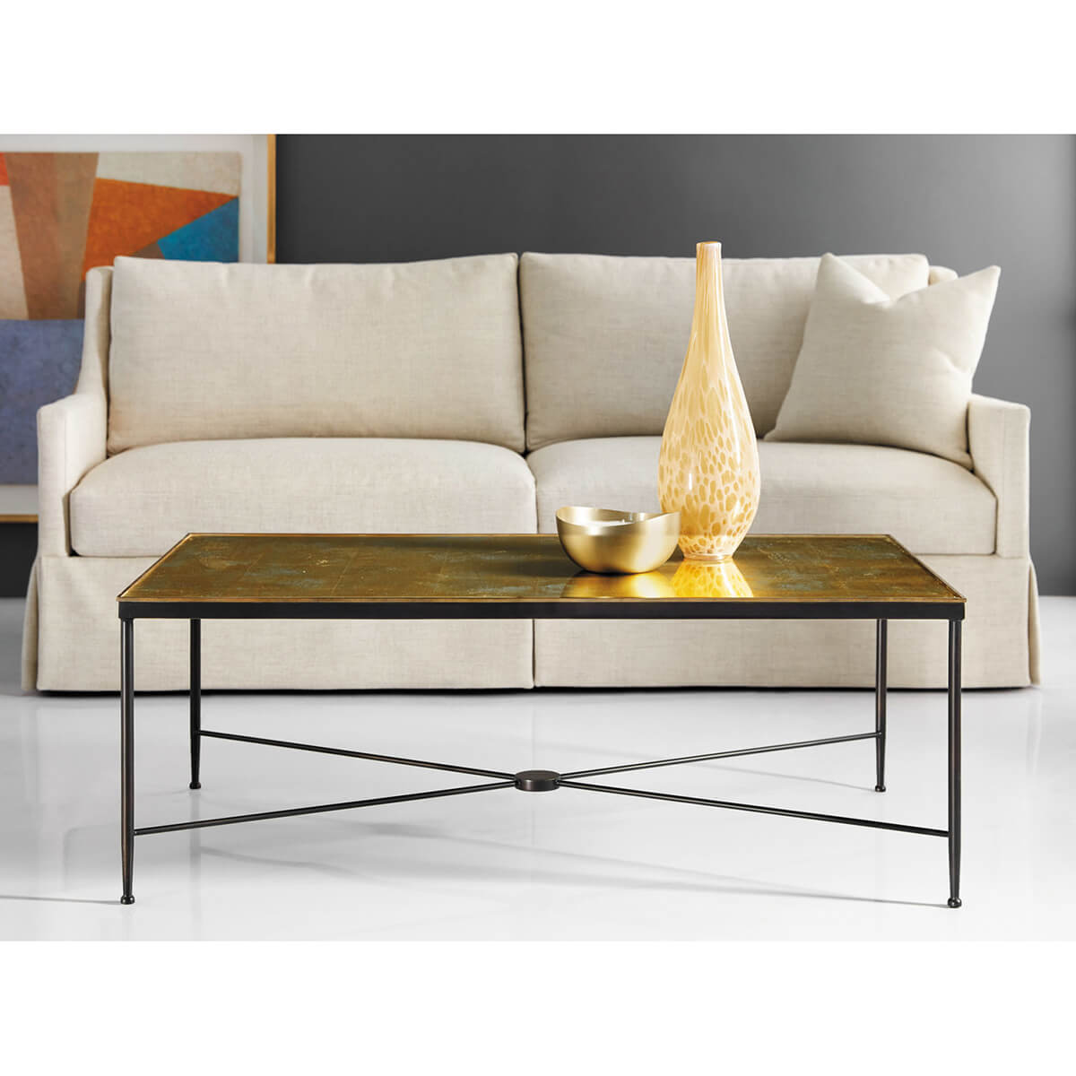 Cocktail table in living room, with sofa and decor.