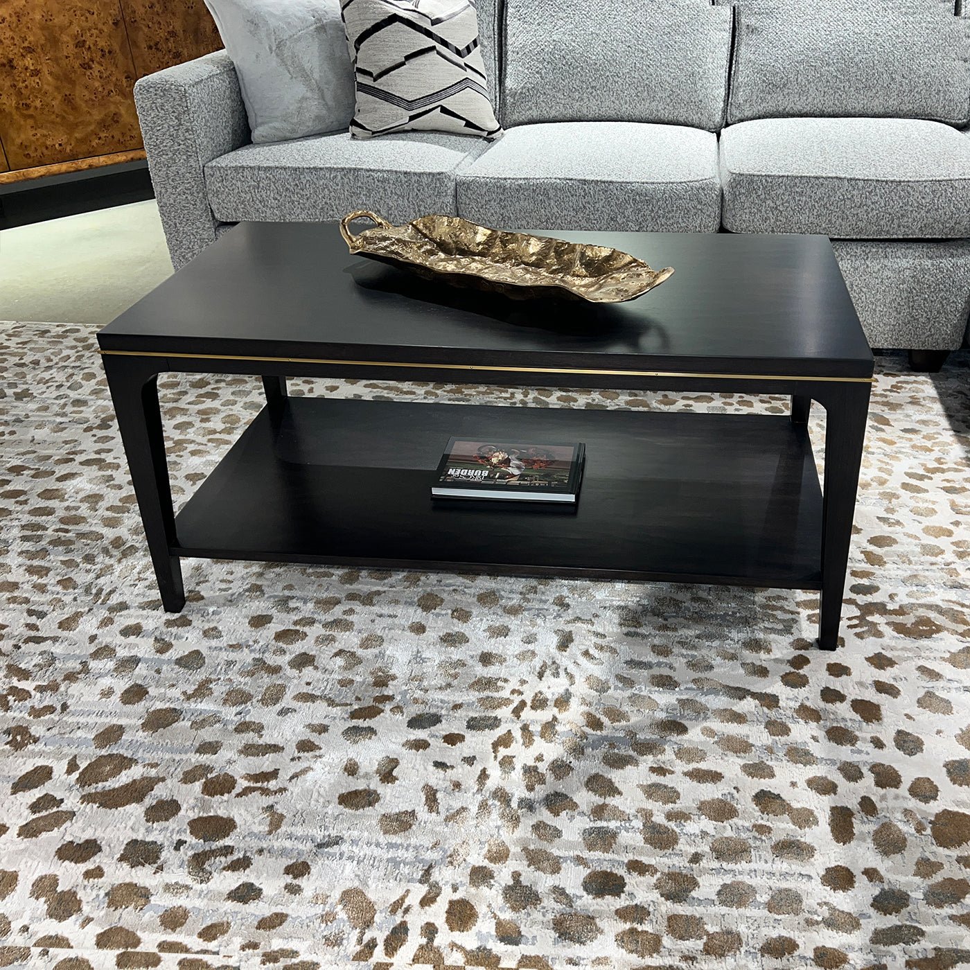 Mid-century coffee table with decor, surrounded by sofa.