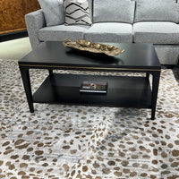 Mid-century coffee table with decor, surrounded by sofa.