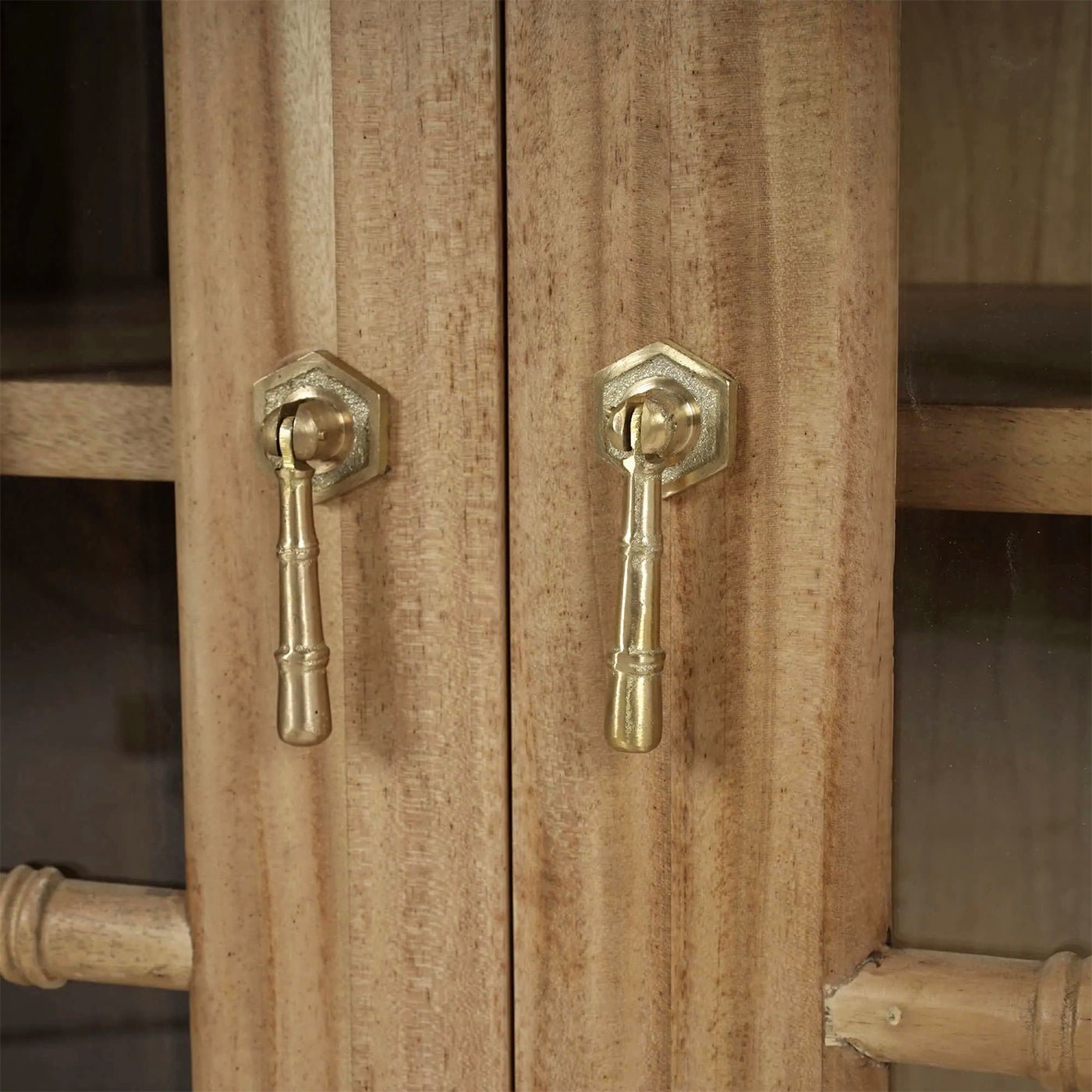 Mid-century credenza brass handles detail, fruitwood background.