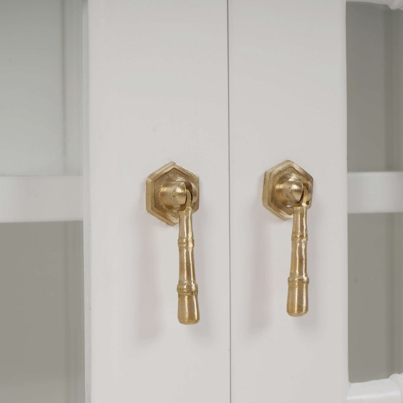 White mid-century credenza, close-up of gold handles.