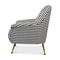 Side profile of a houndstooth mid-century armchair.