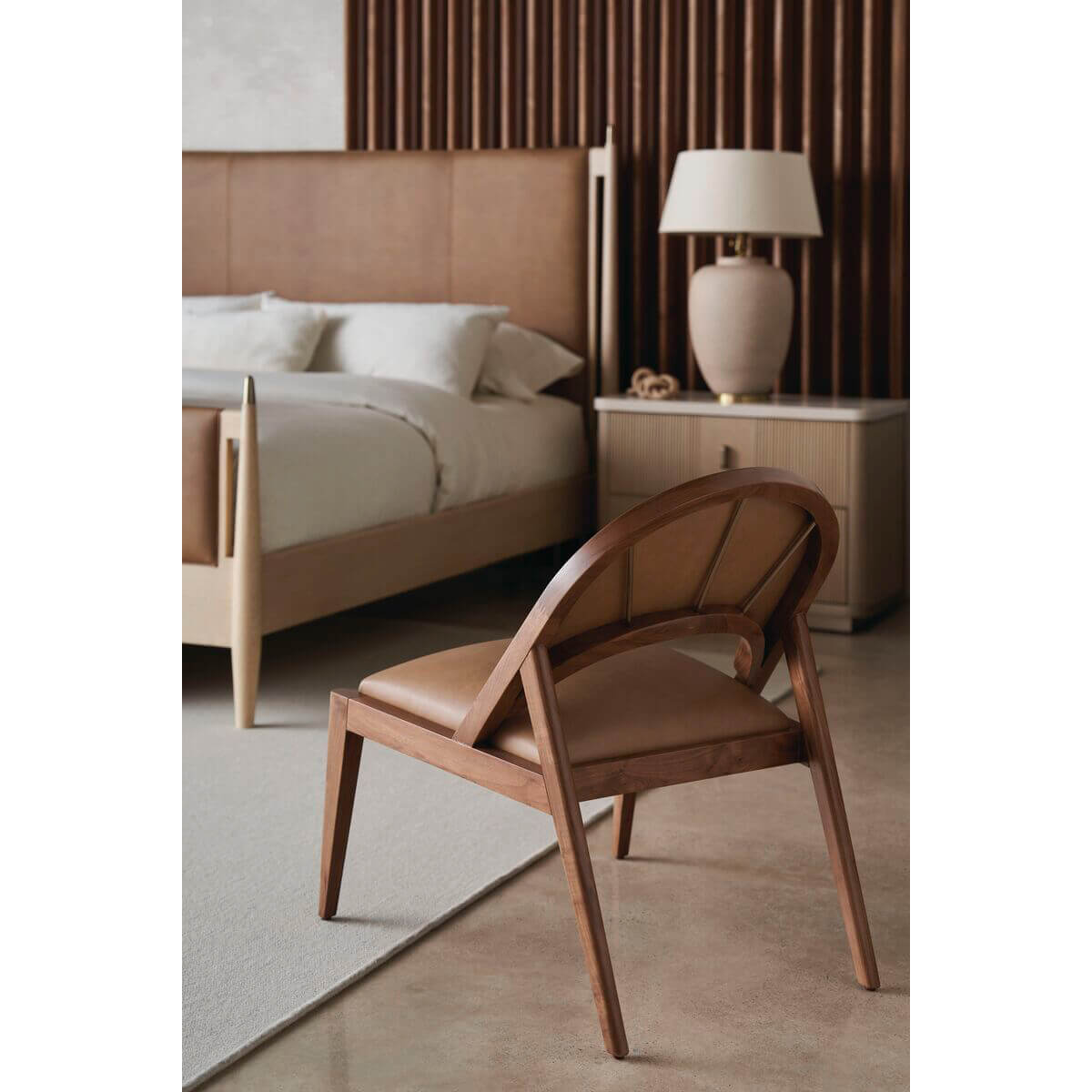 Mid-century chair near leather king bed.