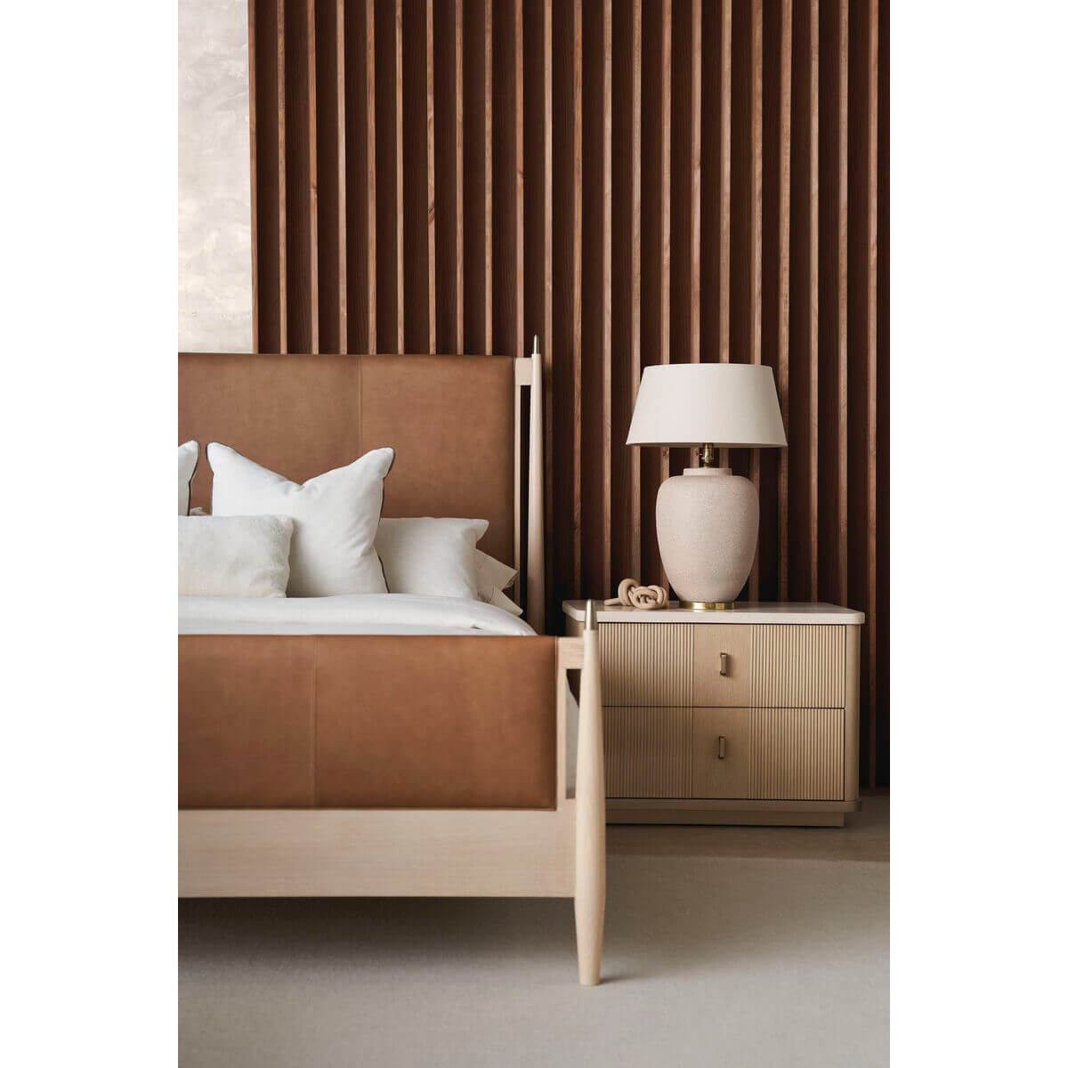 Mid-century leather queen bed, nightstand, and lamp detail.
