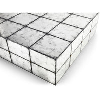 Close-up, mirrored tile surface, cocktail table edge.