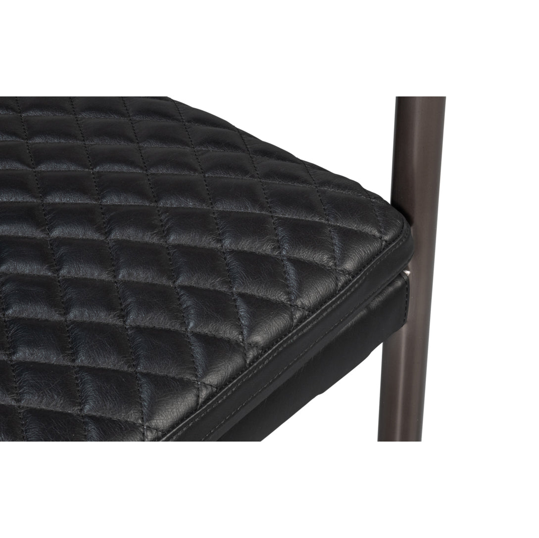 Quilted seat detail on black leather armchair.