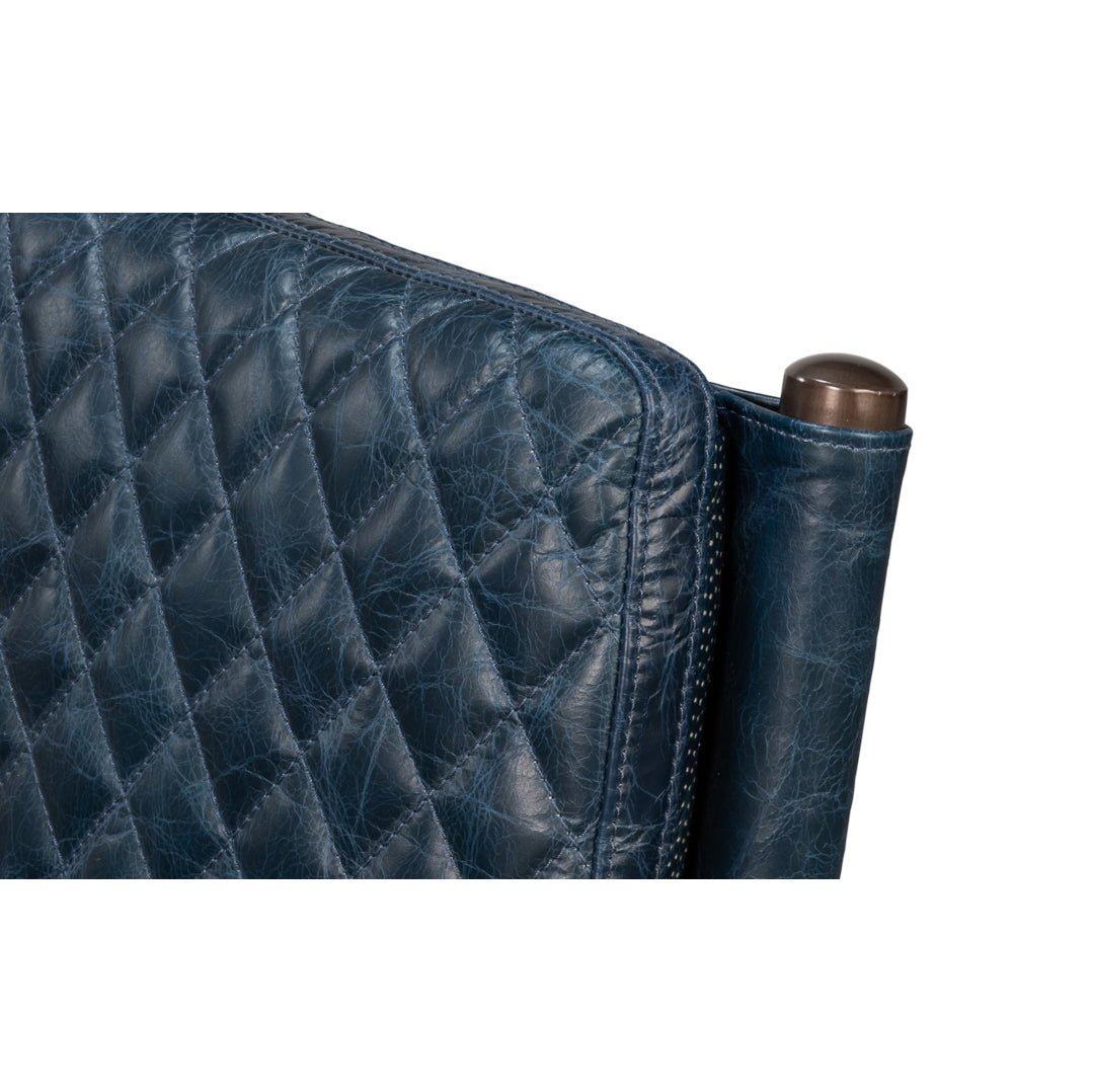 Top corner close-up on blue leather chair, quilted design.