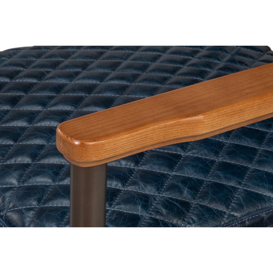 Armrest close-up on blue leather armchair, wood detail.