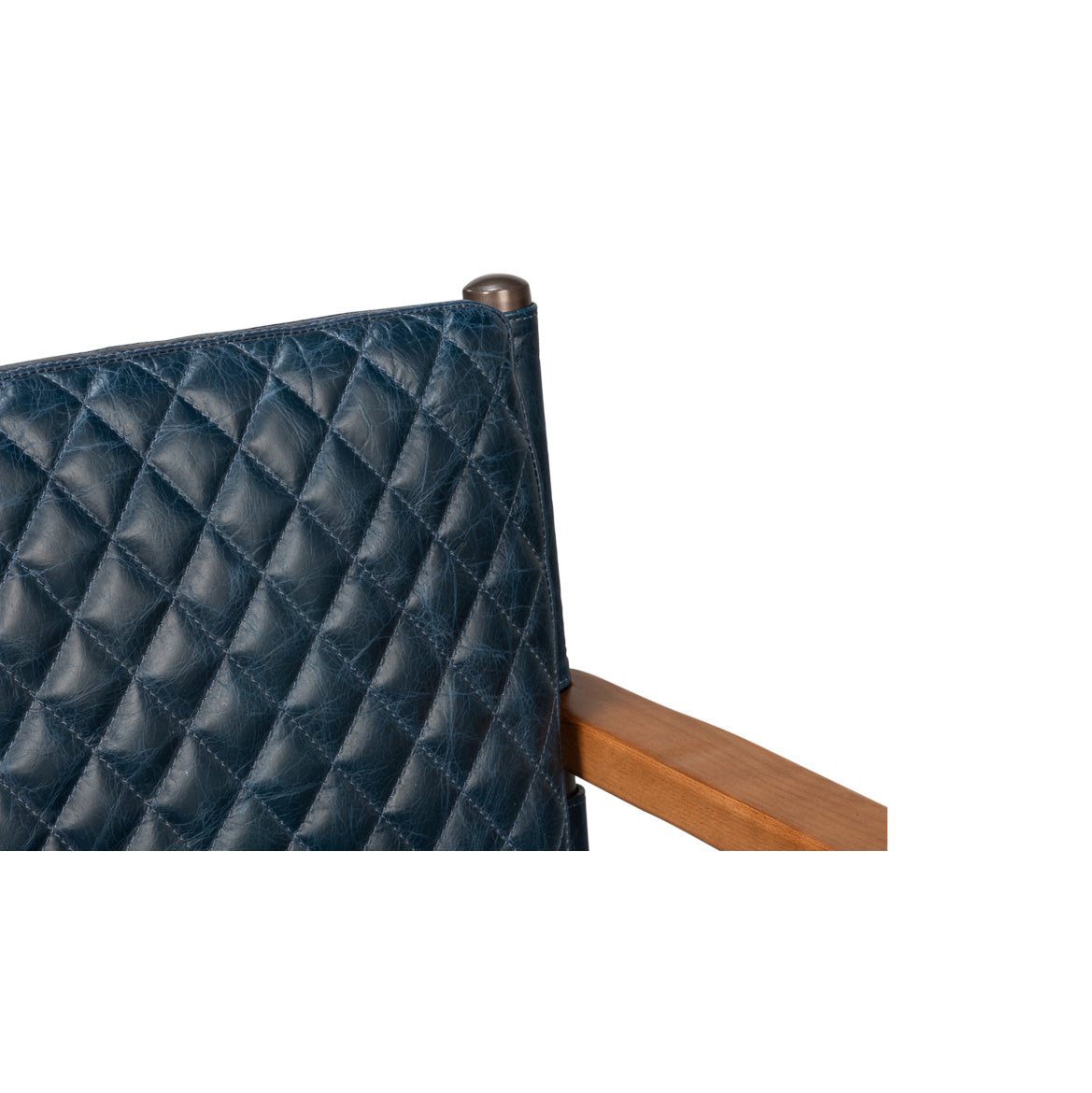 Backrest corner detail on blue leather armchair, quilted texture.