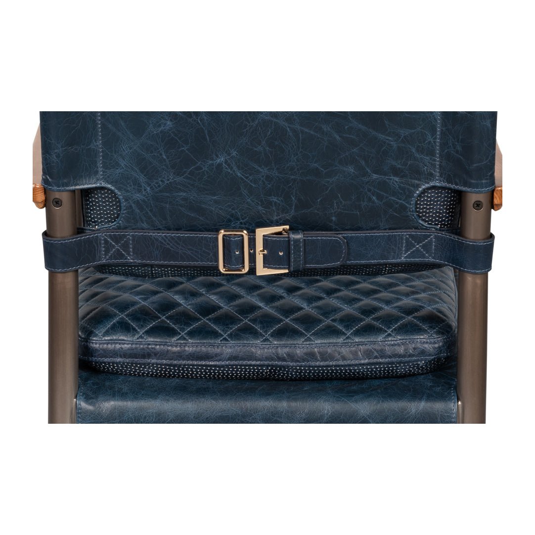 Back buckle detail on blue leather armchair, quilted texture.
