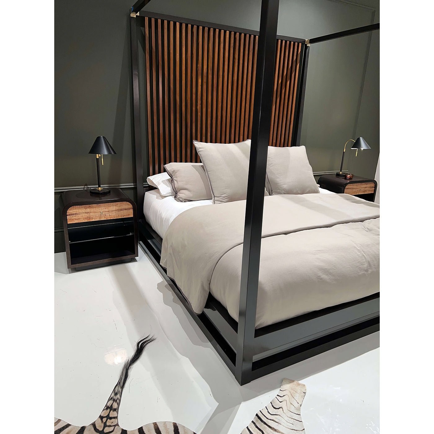 Canopy bed corner showing bedding and nightstand.