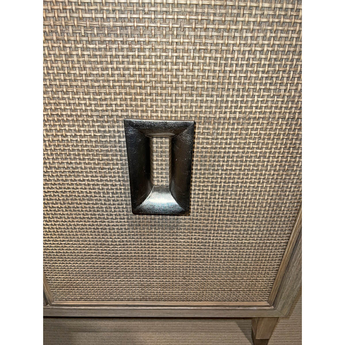 Close-up of credenza door handle with woven texture.