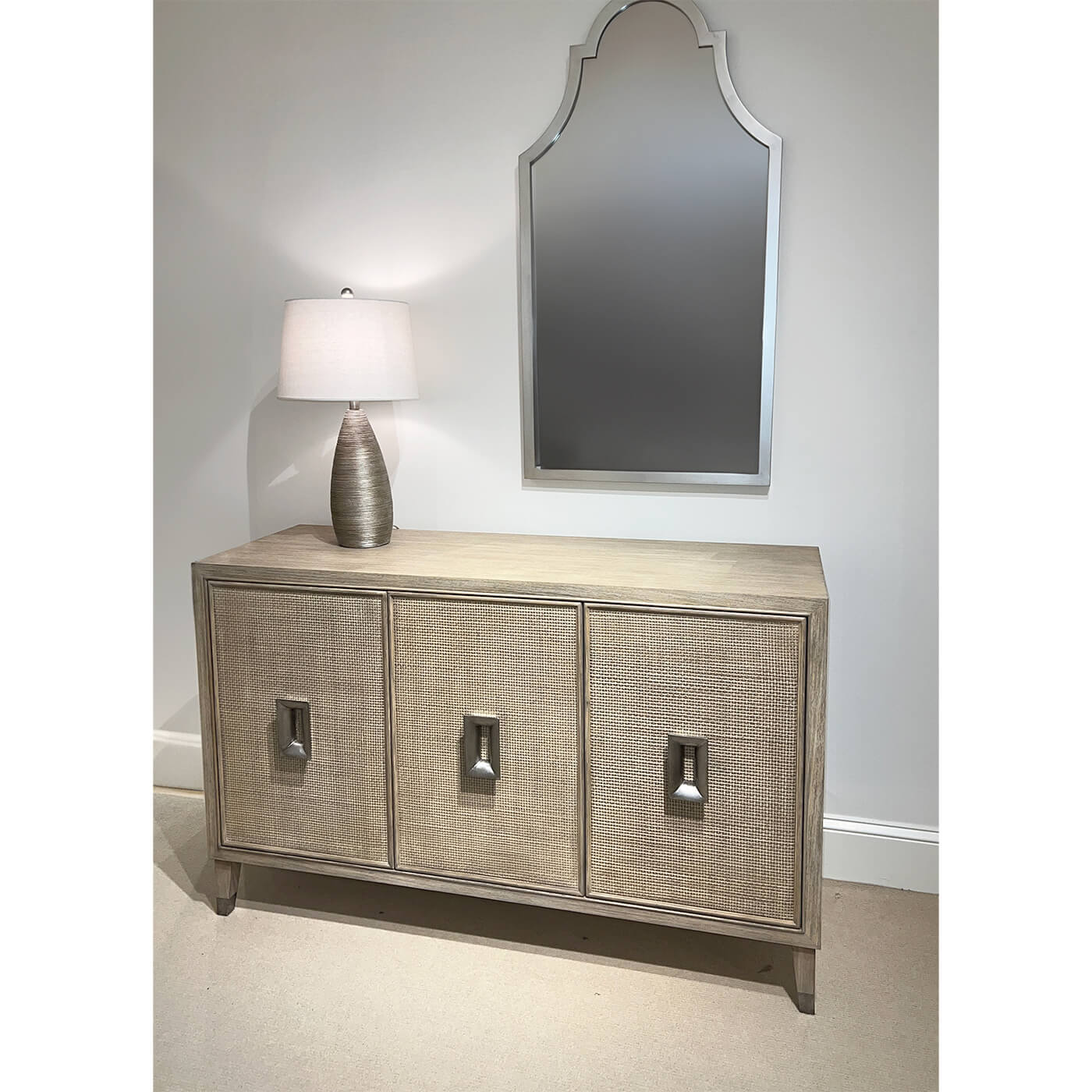 Mid-century modern credenza under mirror, with lamp decoration.