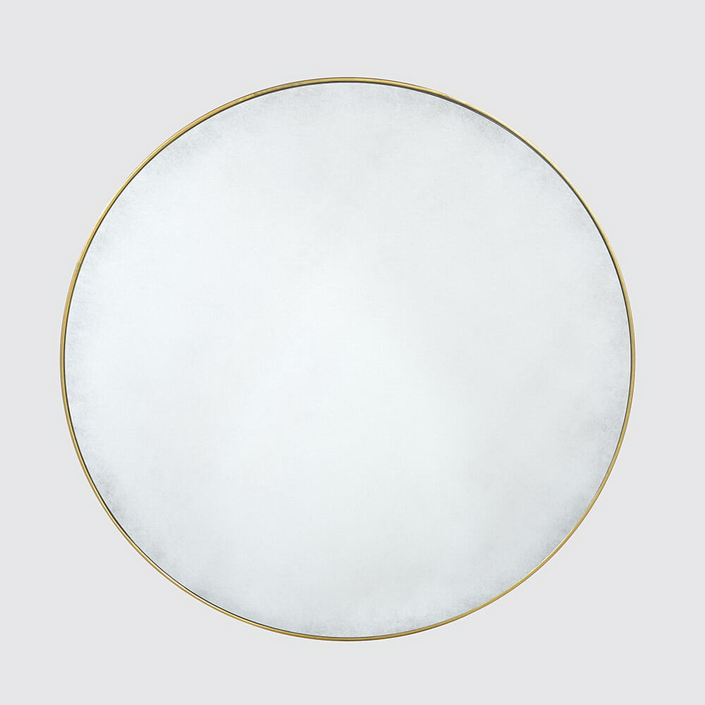 Wall-mounted gilt mirror on light grey background.