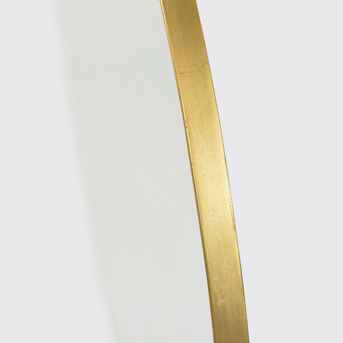Close-up of gold rim on the round mirror.