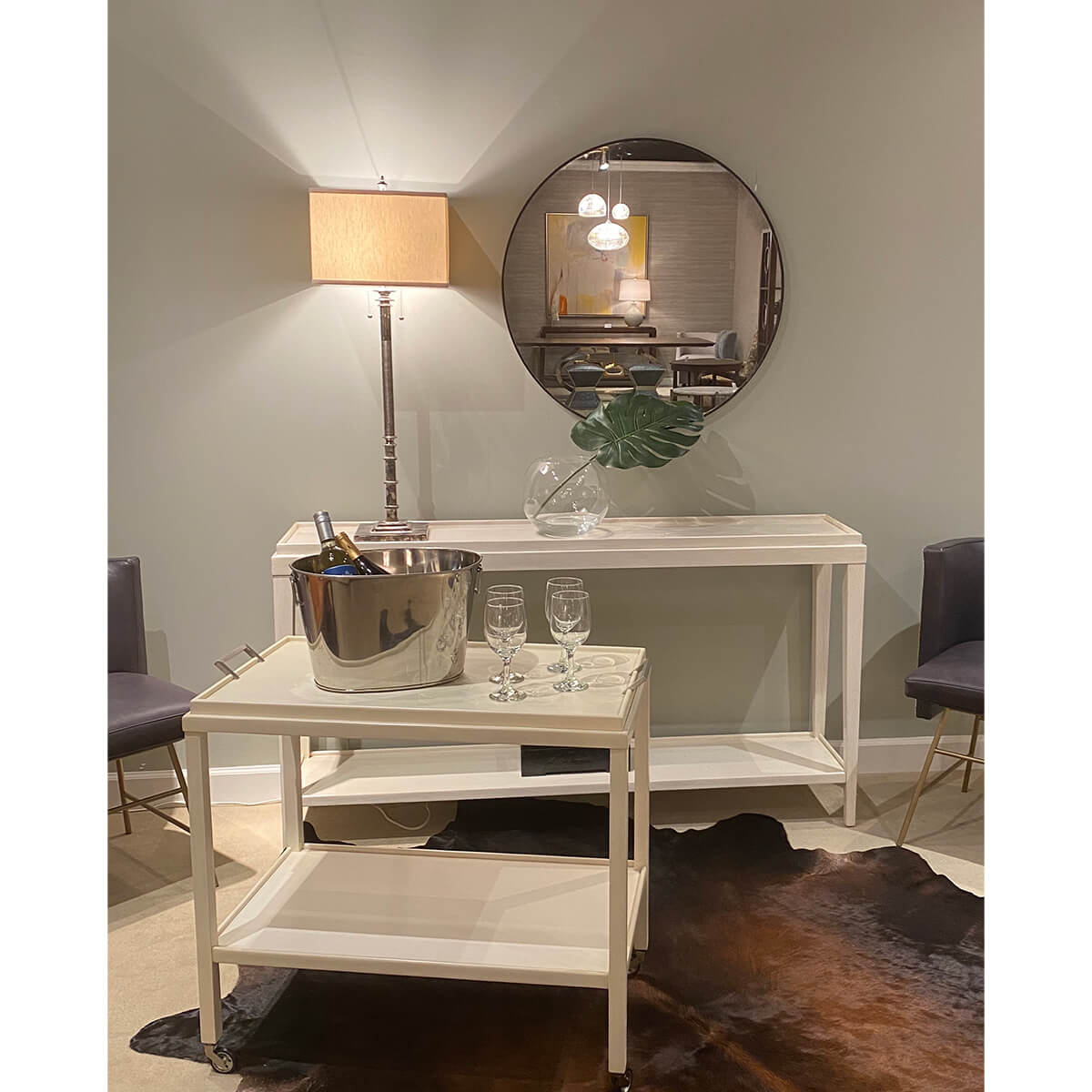 Round mirror in room setting, above console table.