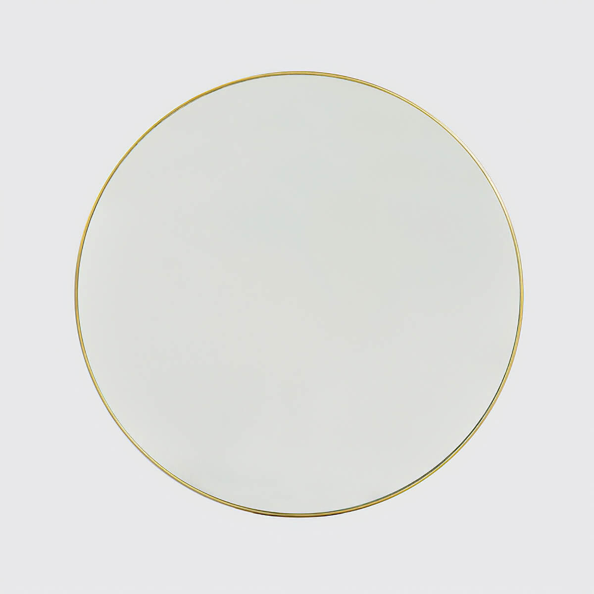 Round mirror with gold rim on grey background.