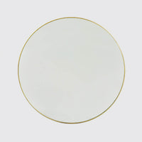 Round mirror with gold rim on grey background.