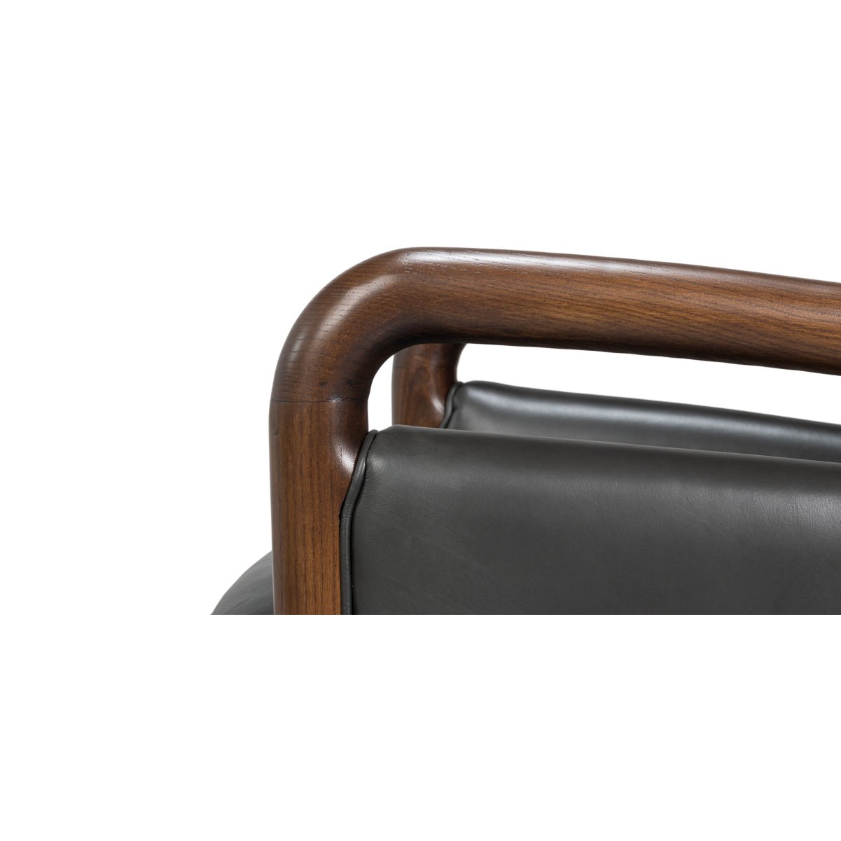 Detail of wooden armrest on mid-century leather armchair.
