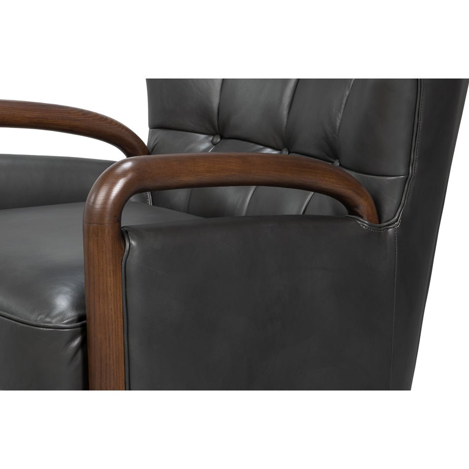 Close-up of wooden armrest on gray leather armchair.