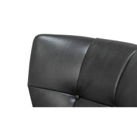 Button tufted back detail on leather armchair.