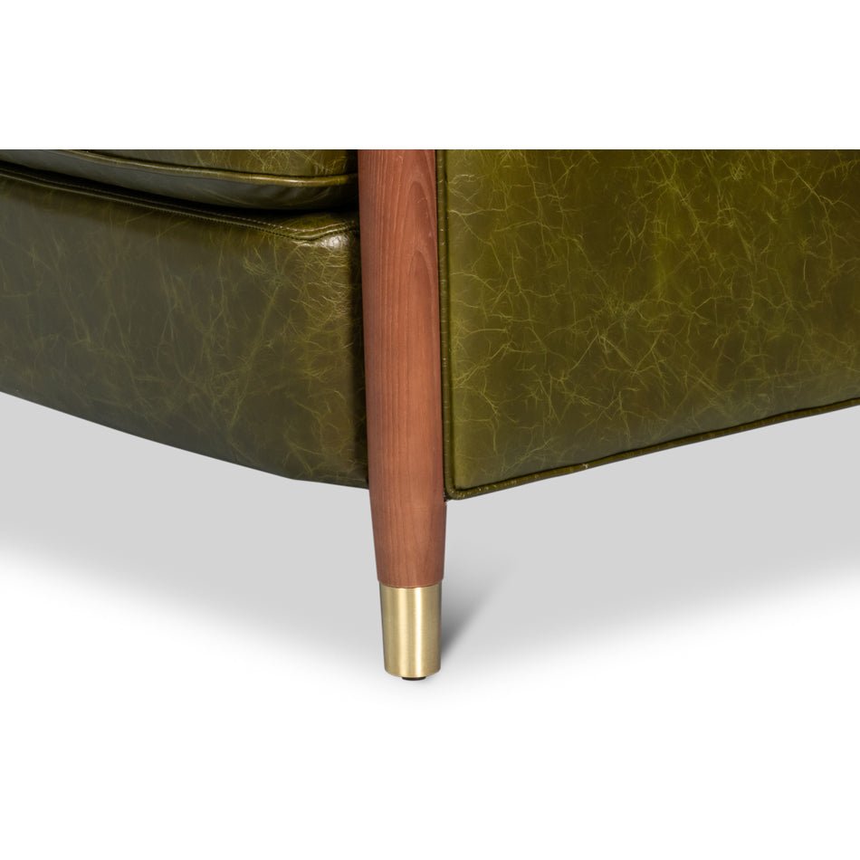 Armchair leg close-up showing wood and brass accents.