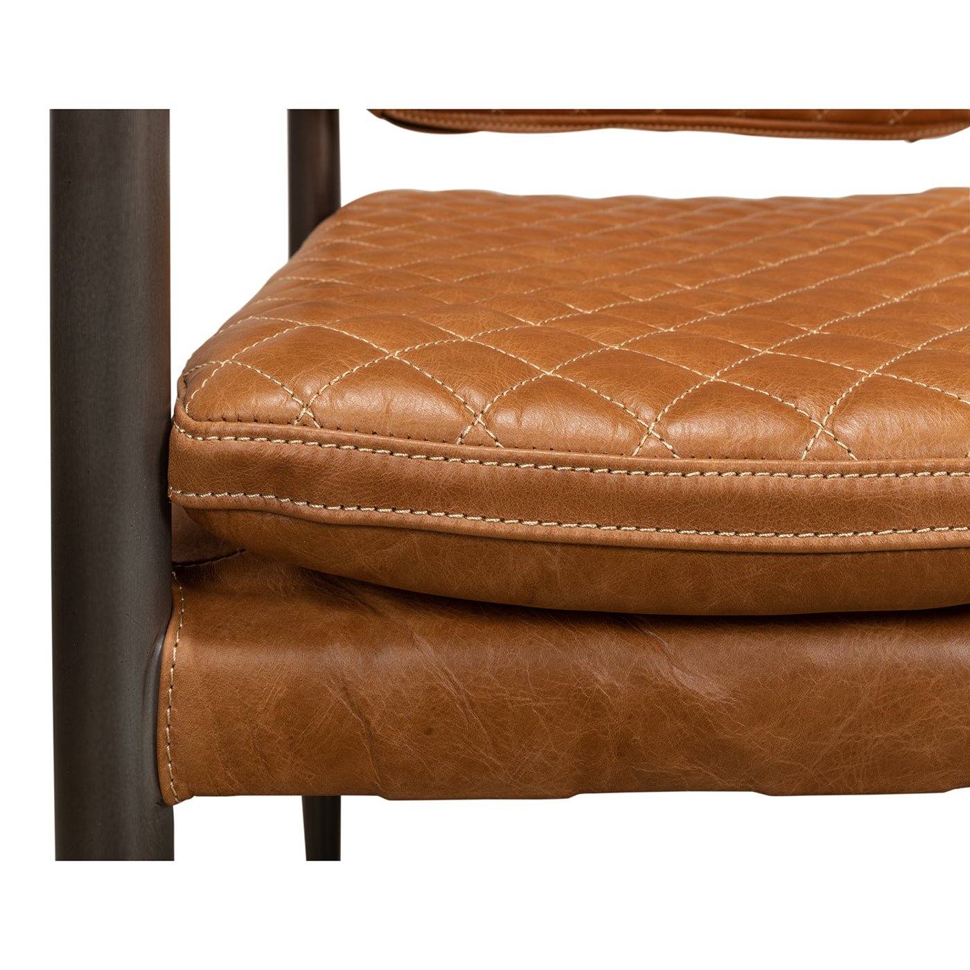 Close-up of quilted leather seat cushion on armchair.