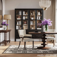 Dining room with round table, chairs, and decor.