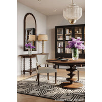 Elegant dining area with round table and rug.