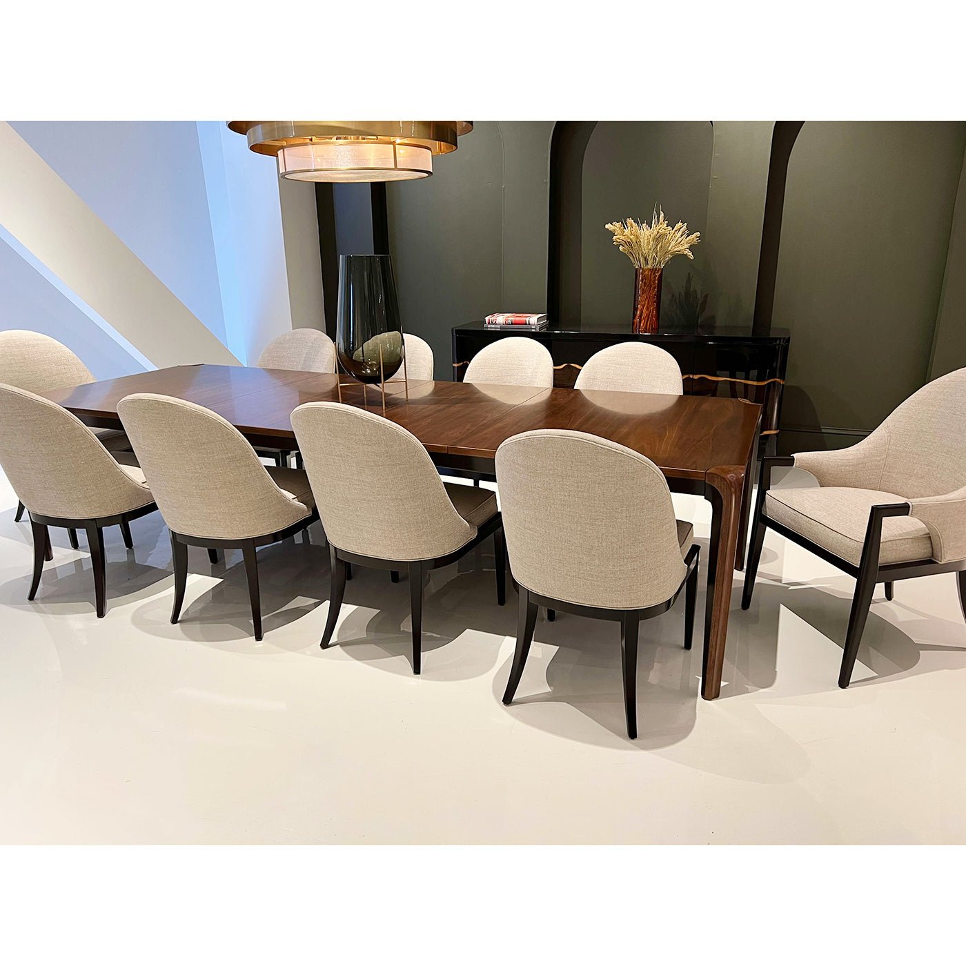 Beige chairs around walnut table, modern dining arrangement.