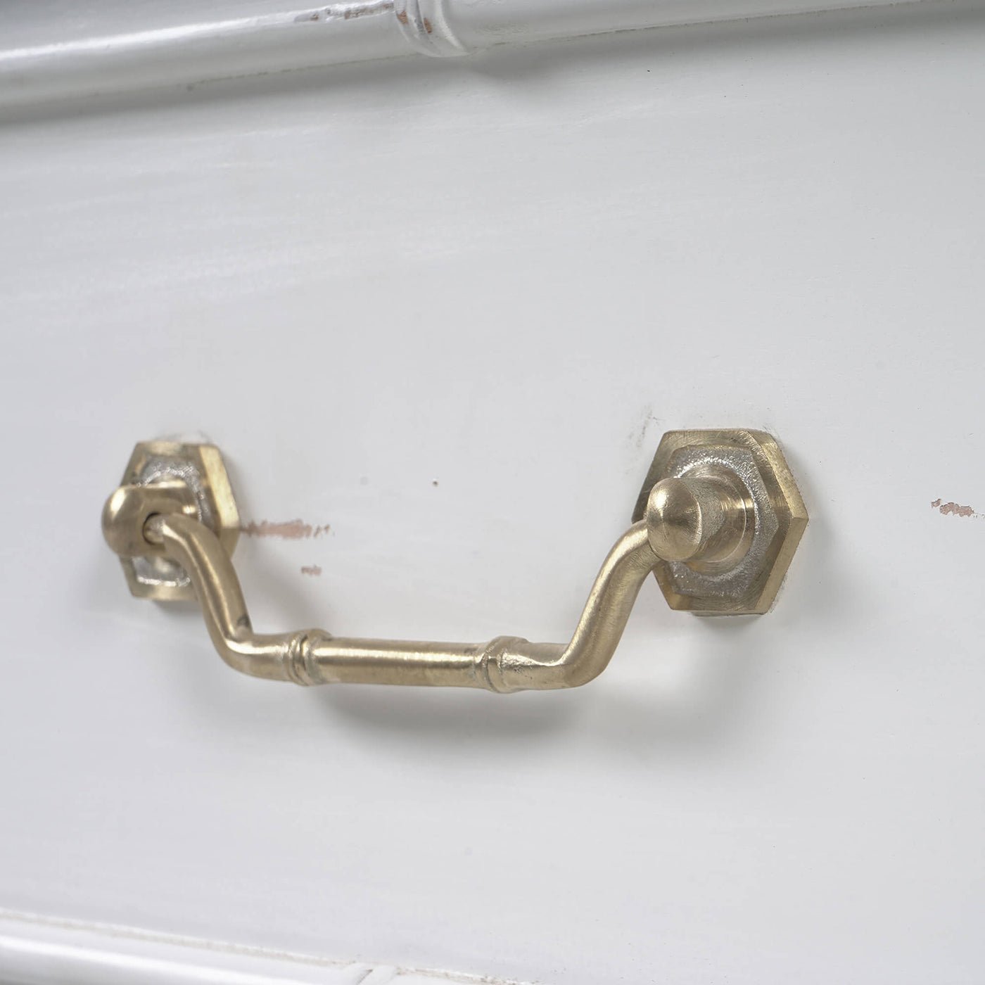 Brass handle detail on white end table drawer