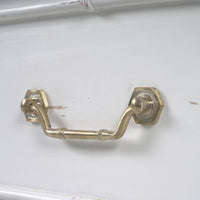 Brass handle detail on white end table drawer