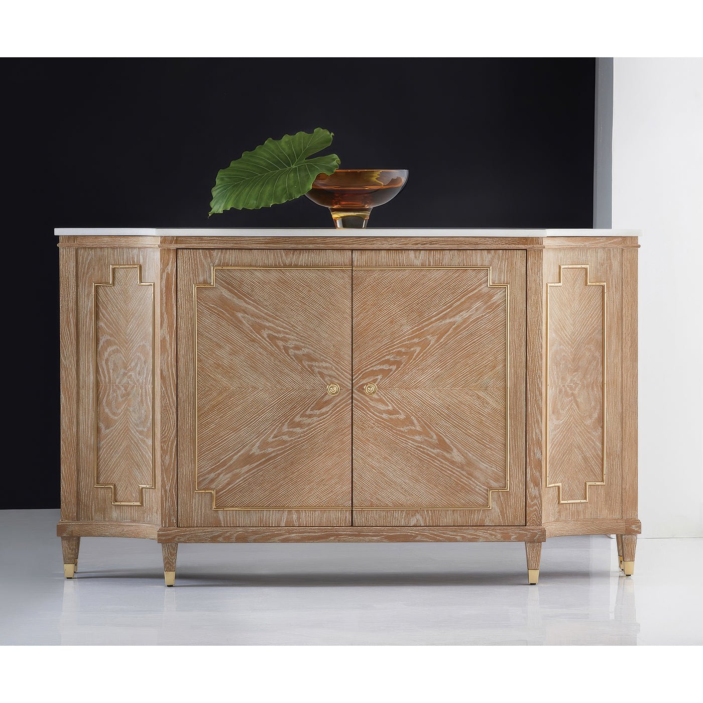 Styled Mid Century oak sideboard against dark wall, decor on top.