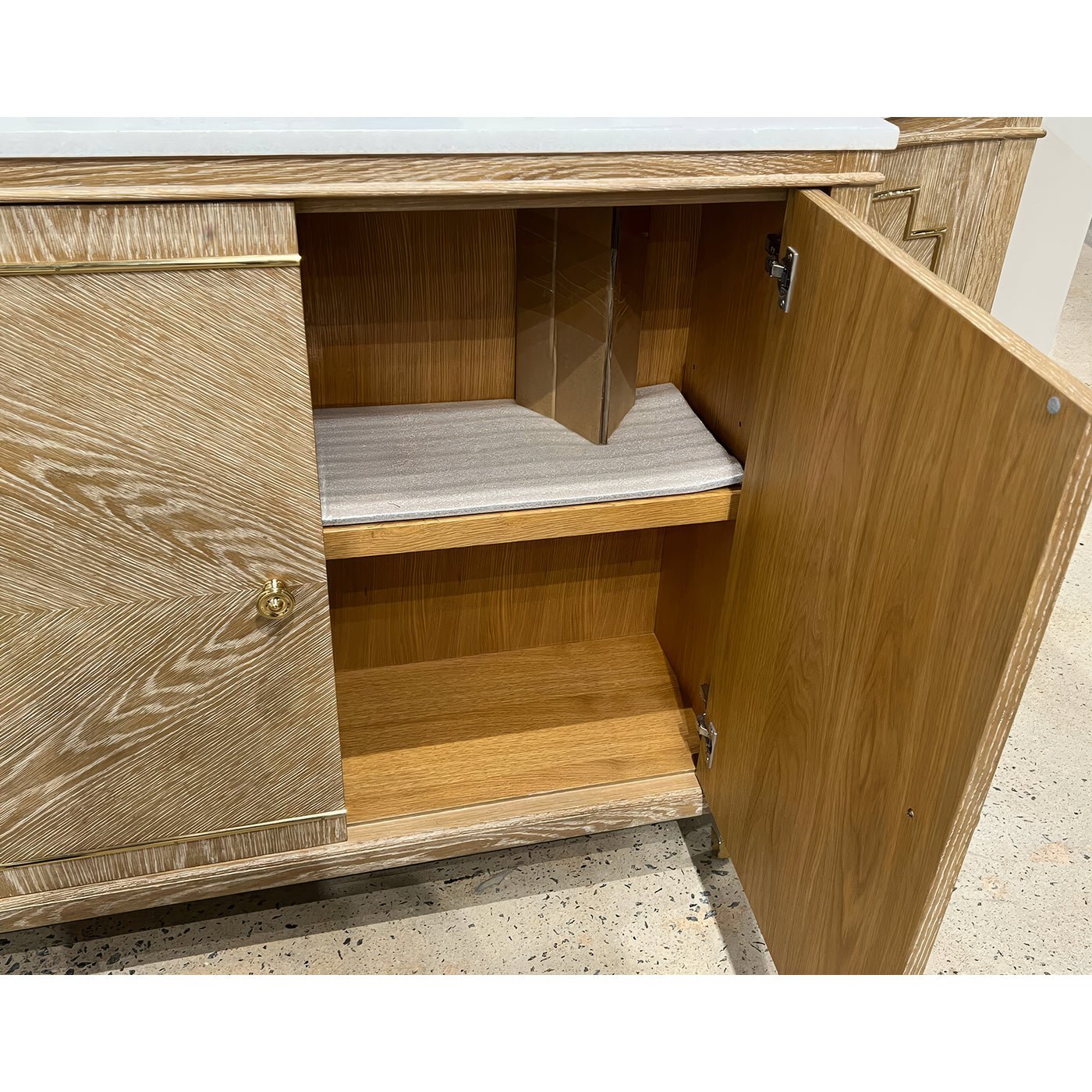Open Mid Century oak sideboard showing interior shelves, wood finish.