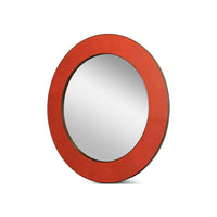 Side angle, orange round leather mirror with reflective surface.